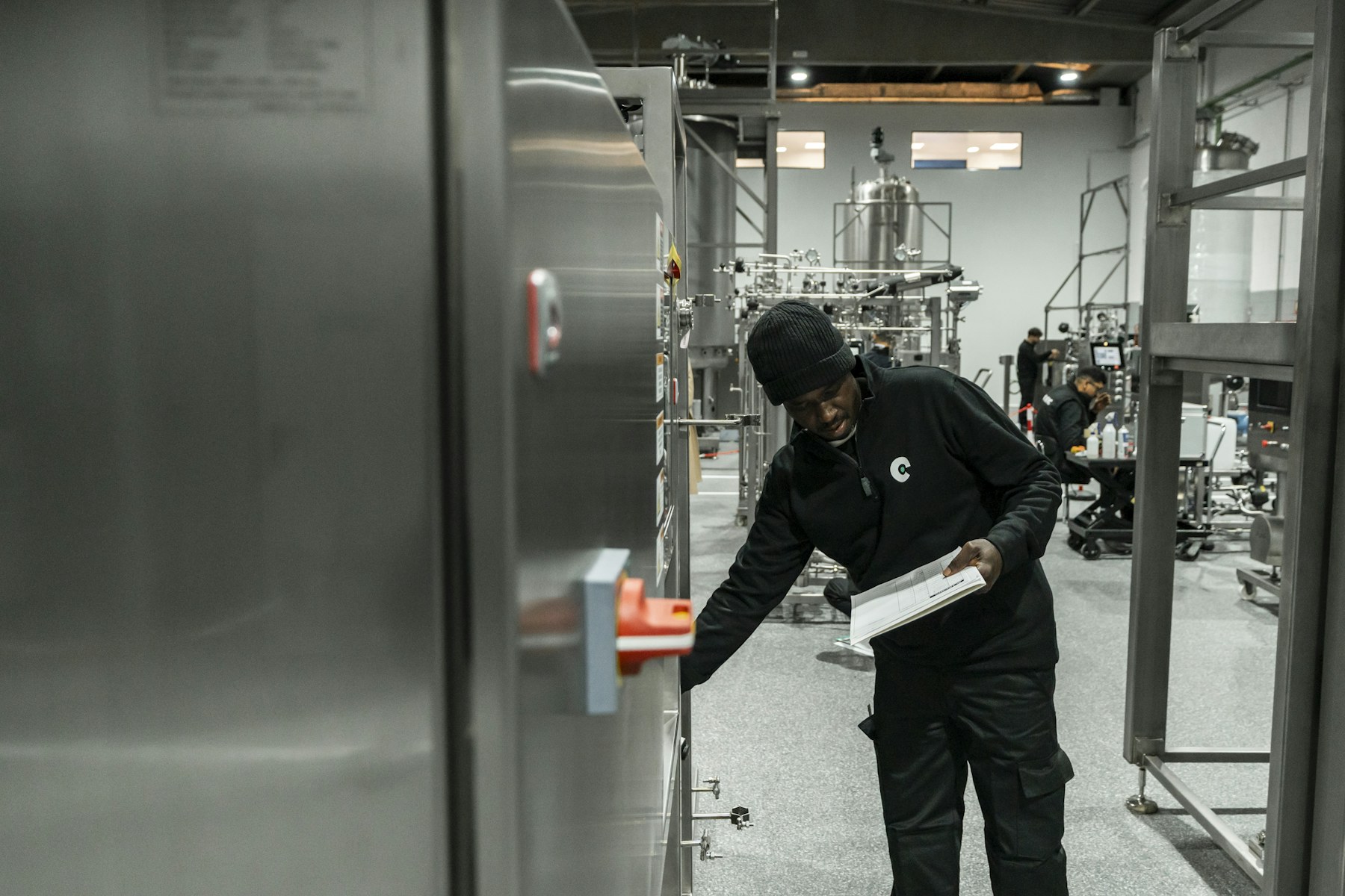 Industrial technician inspecting production equipment with a checklist